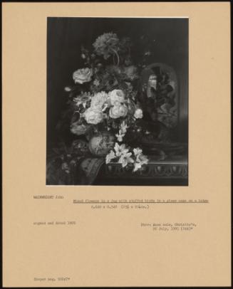 Mixed Flowers In A Jug With Stuffed Birds In A Glass Case On A Ledge