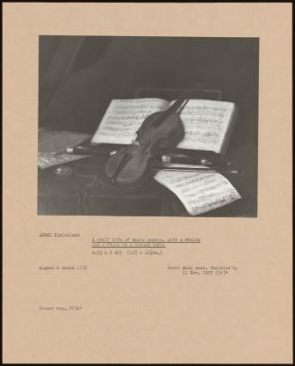 A Still Life Of Music Scores, With A Violin And A Flute On A Draped Table