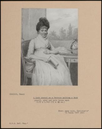 A Lady Seated On A Terrace Holding A Book