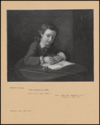 A Boy Drawing At A Desk